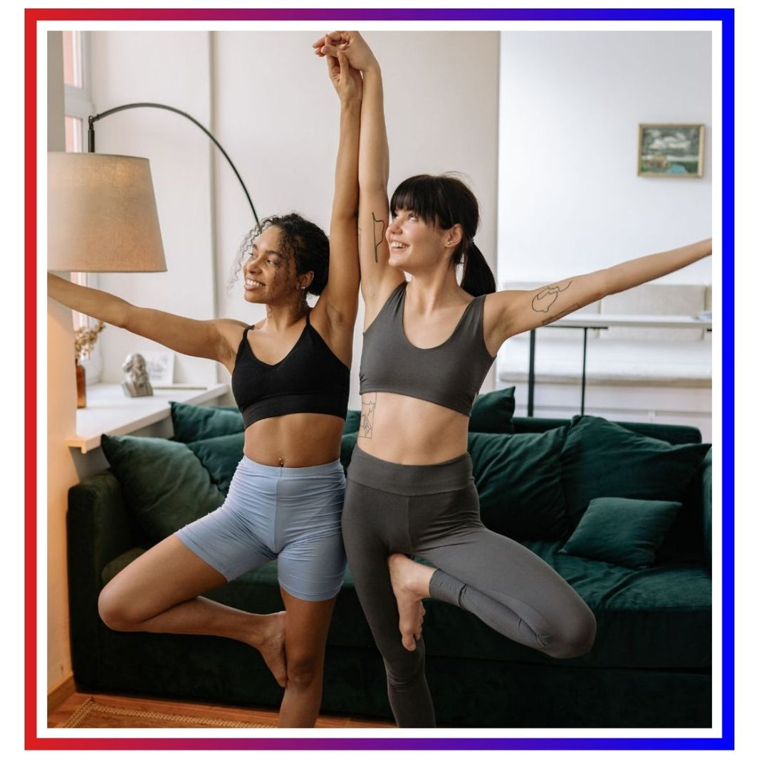 Two women practicing yoga balance indoors